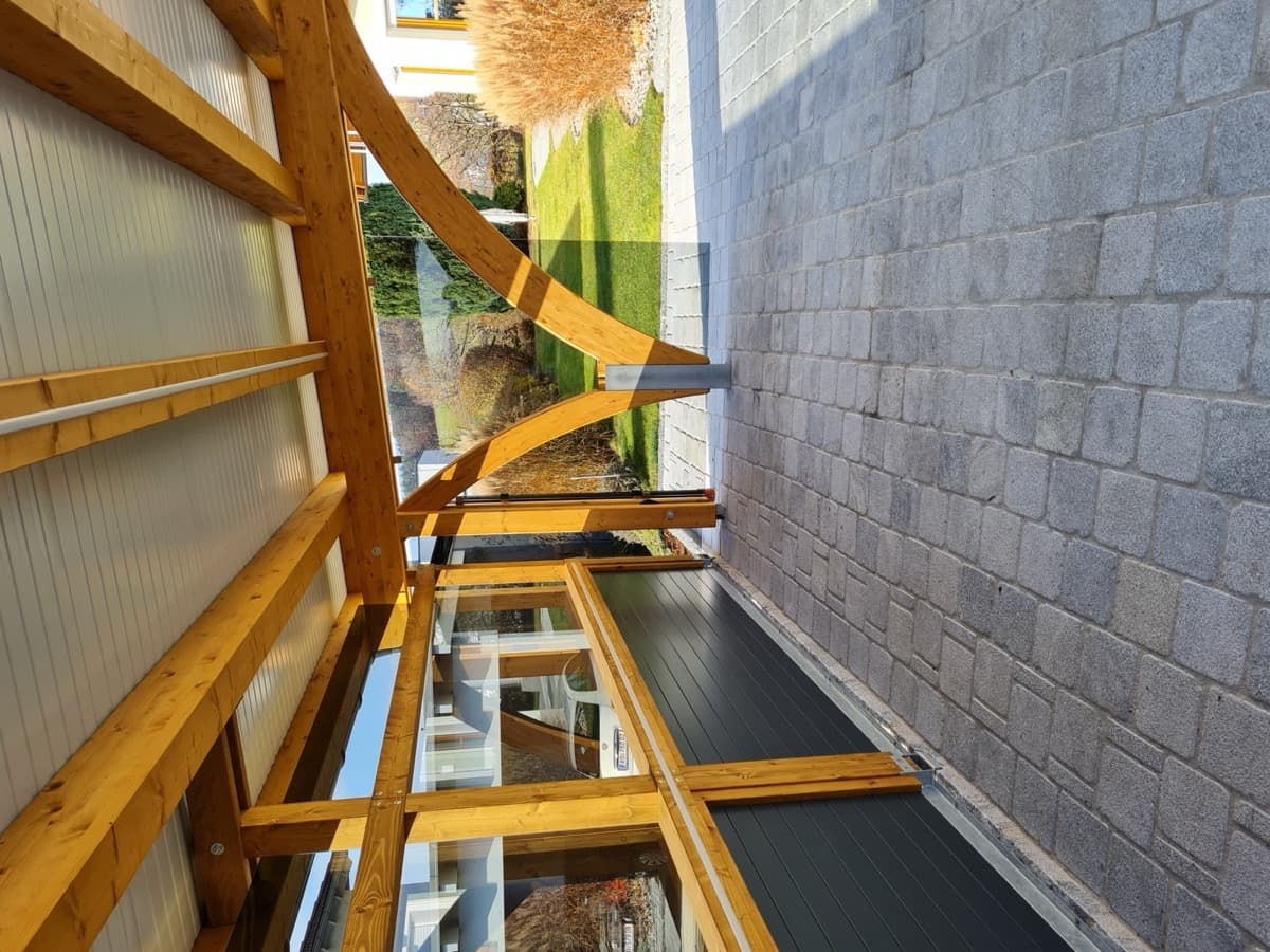 Carport-Detailansicht mit Holz-Bogenkonstruktion und Glasfüllung