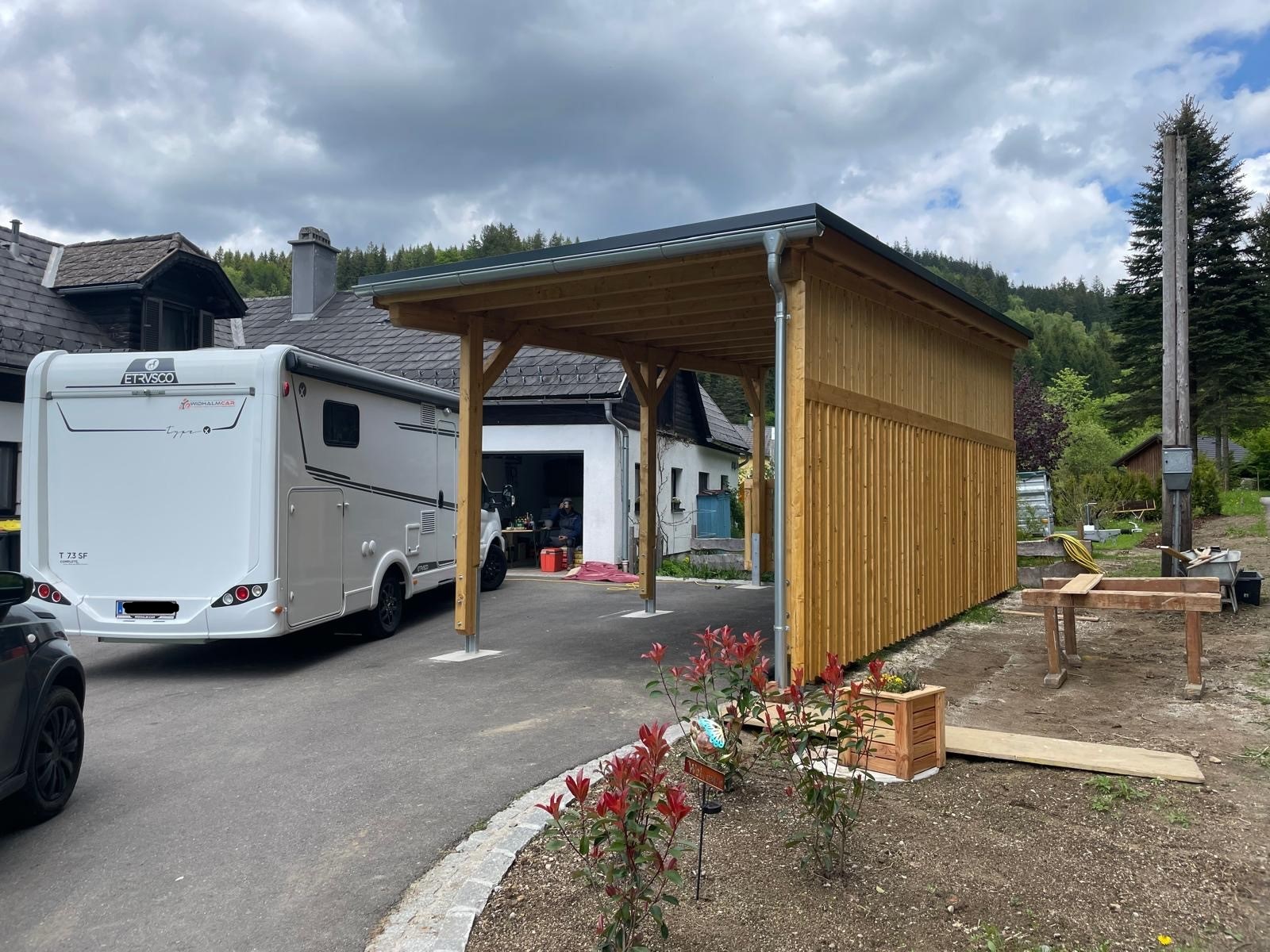 Holz-Carport mit Pultdach und vertikaler Lattung neben Wohnmobil